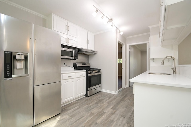 kitchen with crown molding, sink, light hardwood / wood-style flooring, white cabinetry, and stainless steel appliances