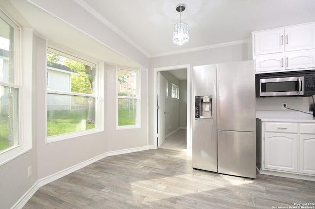 kitchen with white cabinets, crown molding, hanging light fixtures, light hardwood / wood-style floors, and stainless steel appliances