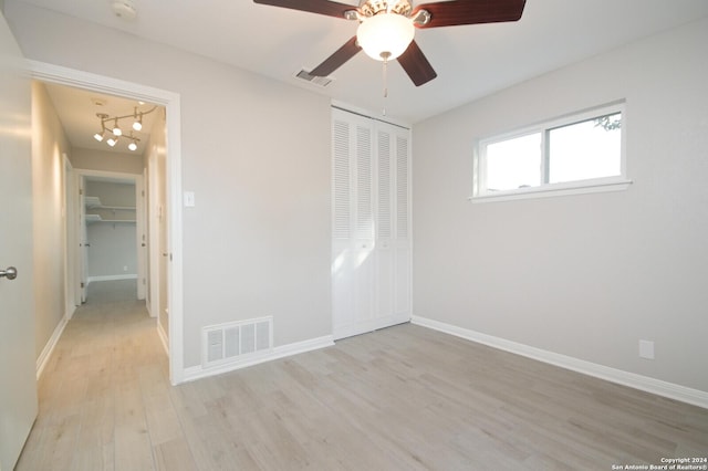 empty room with ceiling fan and light hardwood / wood-style floors