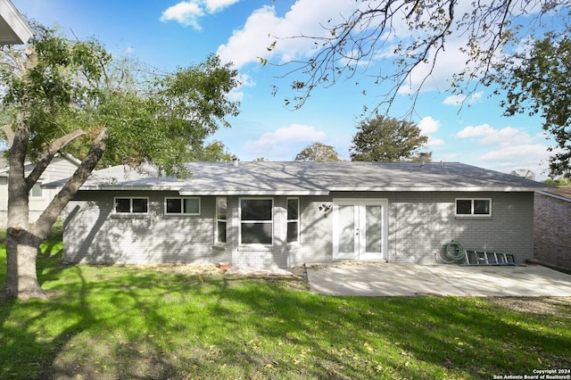 rear view of house with a lawn and a patio