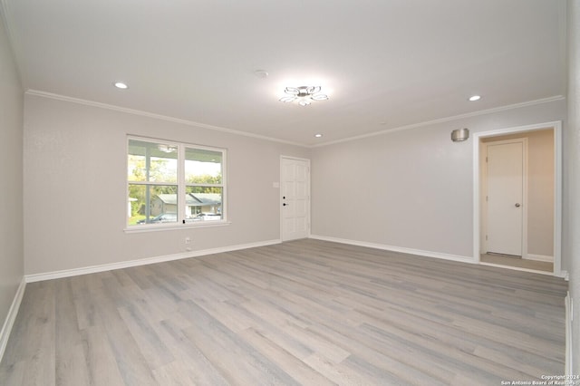 empty room featuring light wood-type flooring and ornamental molding