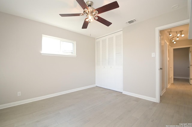 unfurnished bedroom featuring ceiling fan, light hardwood / wood-style flooring, and a closet