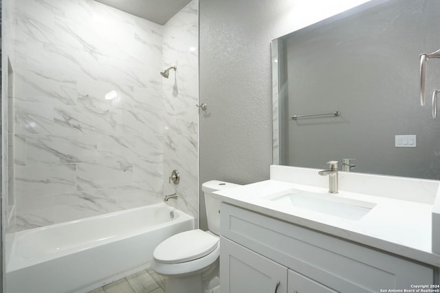 full bathroom featuring vanity, tiled shower / bath combo, and toilet