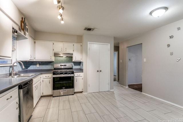 kitchen featuring sink, stainless steel appliances, decorative backsplash, white cabinets, and light wood-type flooring