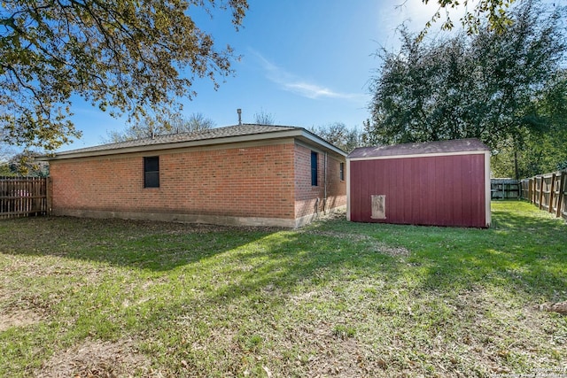 rear view of house with a shed and a lawn