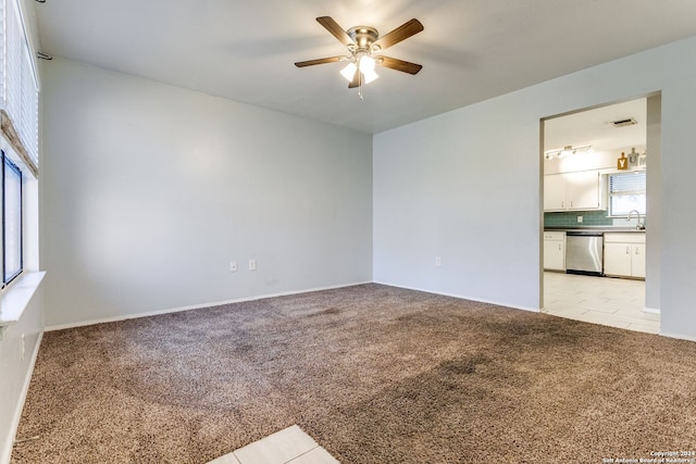 spare room featuring light colored carpet, ceiling fan, and sink