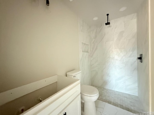 bathroom featuring vanity, toilet, and tiled shower