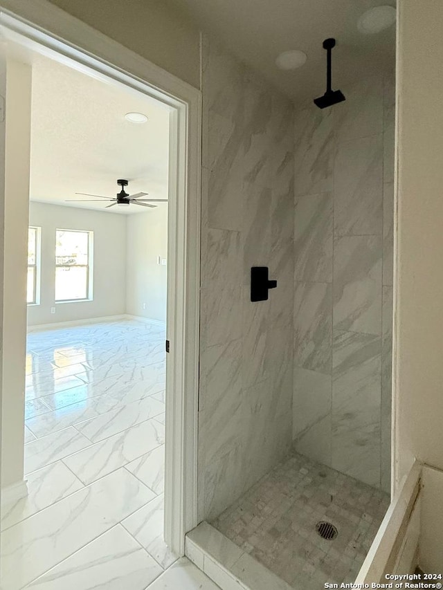 bathroom with ceiling fan and tiled shower