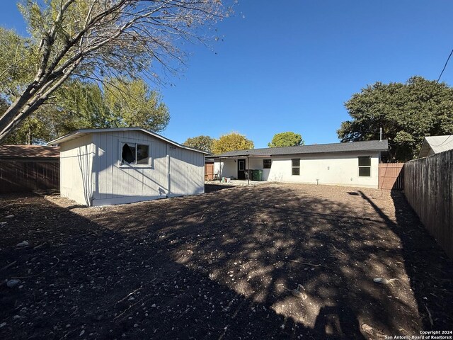 rear view of house featuring a storage unit