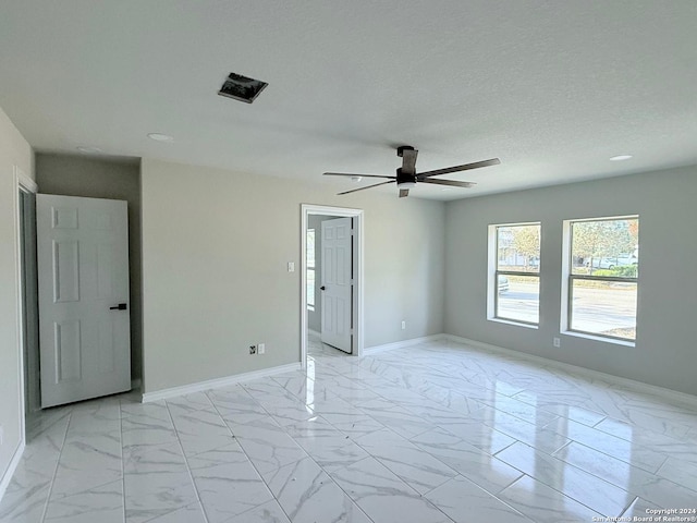 spare room with ceiling fan and a textured ceiling