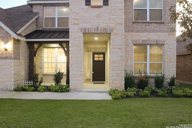 view of exterior entry featuring a yard