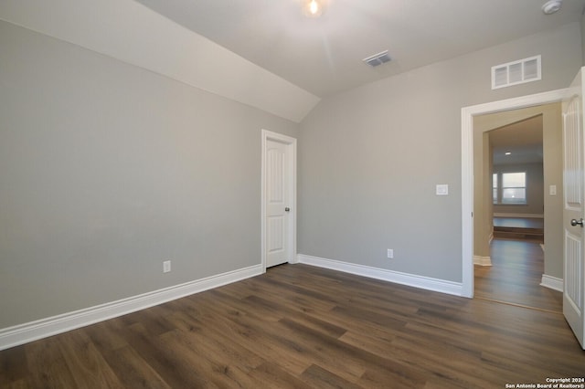 unfurnished room featuring dark hardwood / wood-style flooring and lofted ceiling