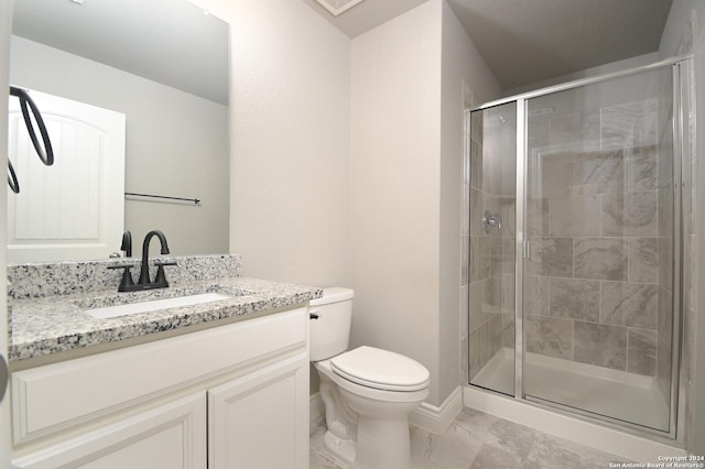 bathroom with vanity, toilet, and a shower with shower door