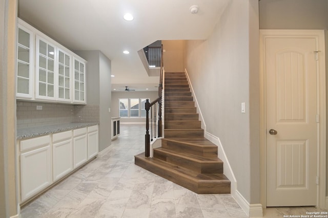 staircase featuring ceiling fan