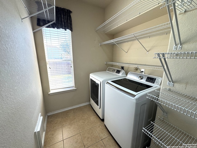 laundry room with washing machine and dryer and light tile patterned floors