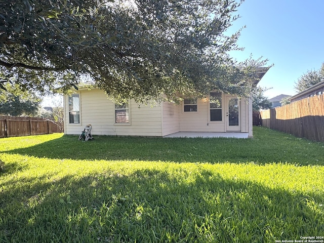 back of house featuring a yard and a patio