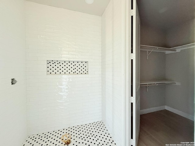 bathroom featuring wood-type flooring and tiled shower