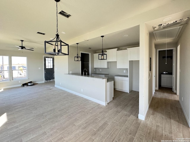 kitchen with white cabinets, decorative light fixtures, light hardwood / wood-style flooring, ceiling fan, and stone countertops