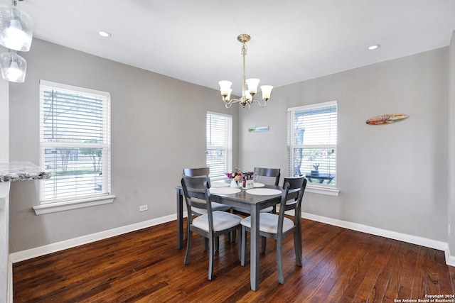 dining space with dark hardwood / wood-style floors and a notable chandelier