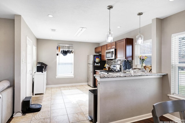 kitchen with kitchen peninsula, appliances with stainless steel finishes, backsplash, and plenty of natural light