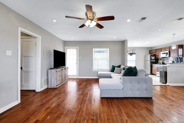 unfurnished living room featuring ceiling fan and dark hardwood / wood-style flooring