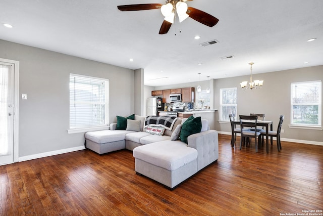 living room with dark wood-type flooring and ceiling fan with notable chandelier