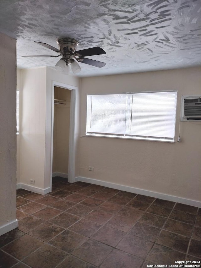 unfurnished bedroom featuring a wall mounted air conditioner, ceiling fan, and a closet