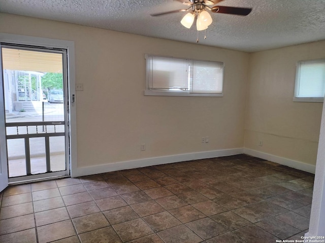 tiled spare room featuring ceiling fan and a textured ceiling