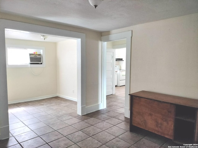 tiled spare room featuring cooling unit and a textured ceiling