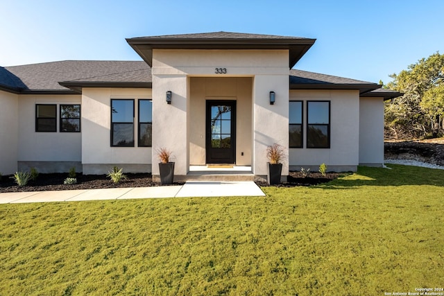 doorway to property with a lawn