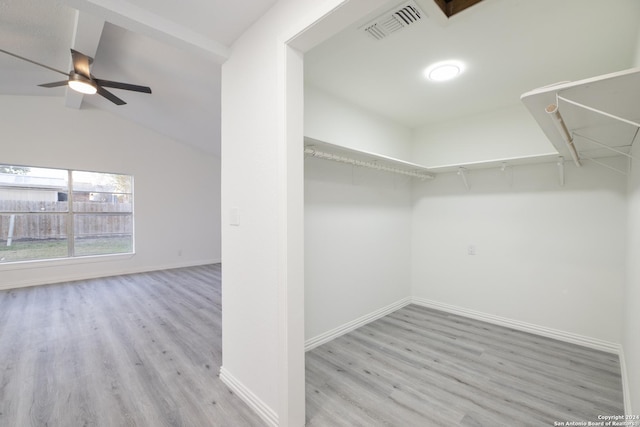 spacious closet featuring ceiling fan, light hardwood / wood-style floors, and vaulted ceiling