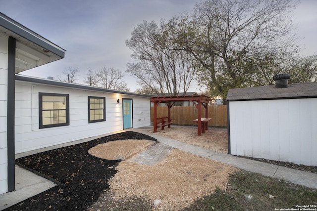 view of patio / terrace with a pergola and a shed