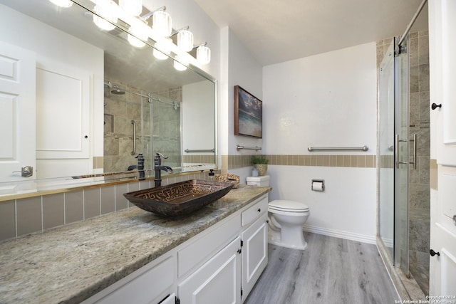 bathroom featuring hardwood / wood-style floors, vanity, toilet, and an enclosed shower