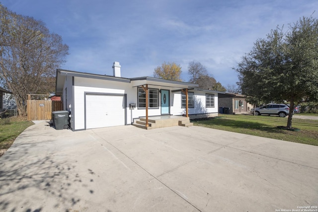 ranch-style home with covered porch, a garage, and a front yard