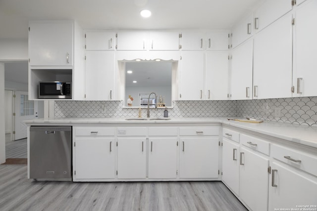 kitchen with sink, white cabinets, light hardwood / wood-style floors, and appliances with stainless steel finishes