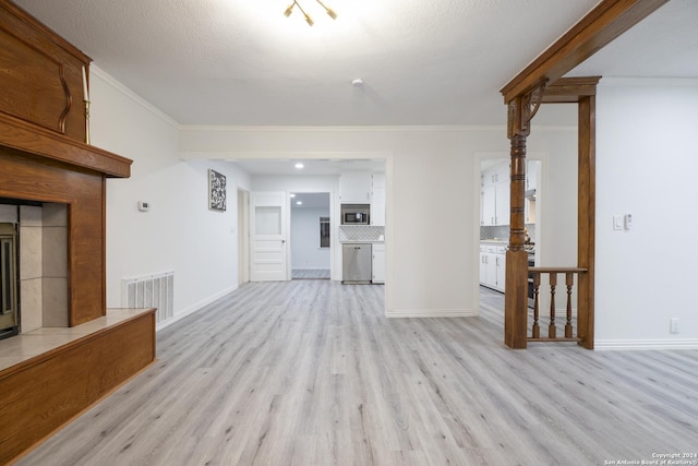 unfurnished living room with a fireplace, a textured ceiling, light hardwood / wood-style floors, and crown molding