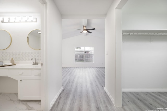 bathroom with ceiling fan, hardwood / wood-style floors, vanity, and vaulted ceiling