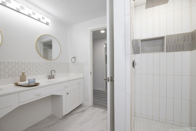 bathroom featuring a tile shower and vanity