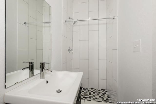 bathroom with a tile shower and sink