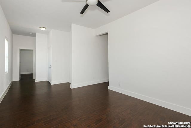 empty room with ceiling fan and dark wood-type flooring