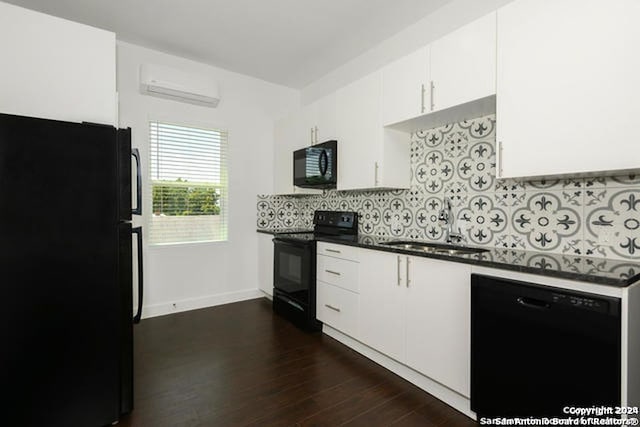 kitchen featuring dark wood-type flooring, black appliances, an AC wall unit, tasteful backsplash, and white cabinetry