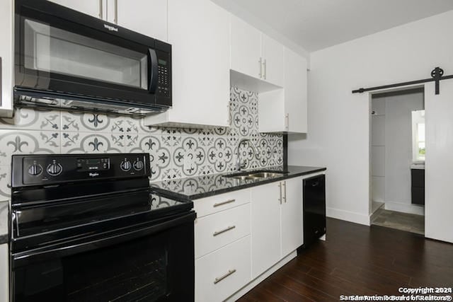 kitchen featuring a barn door, white cabinetry, dark wood-type flooring, and black appliances