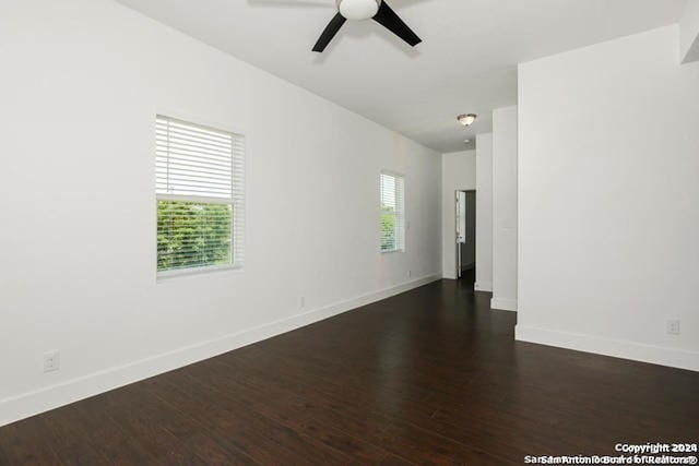 empty room featuring dark hardwood / wood-style floors, ceiling fan, and a healthy amount of sunlight