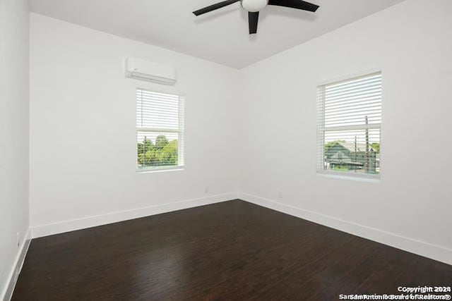 empty room featuring a wall mounted air conditioner, dark hardwood / wood-style flooring, and ceiling fan