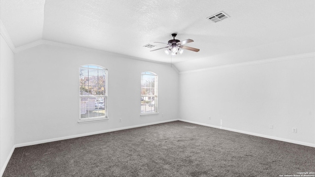 spare room featuring a textured ceiling, dark carpet, and vaulted ceiling