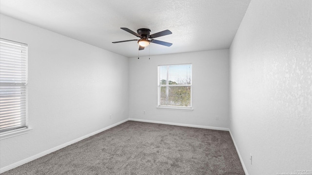 carpeted spare room with a textured ceiling and ceiling fan