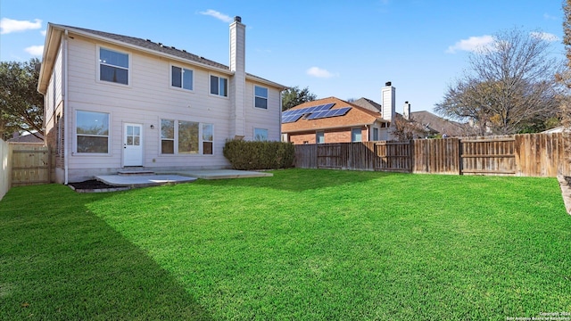 back of property with a yard and a patio area