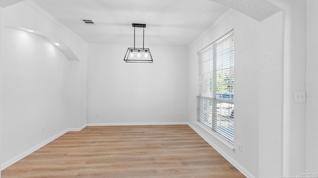 unfurnished dining area featuring light hardwood / wood-style floors and ornamental molding