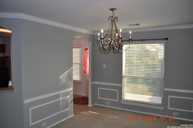 unfurnished dining area featuring crown molding, carpet, and an inviting chandelier