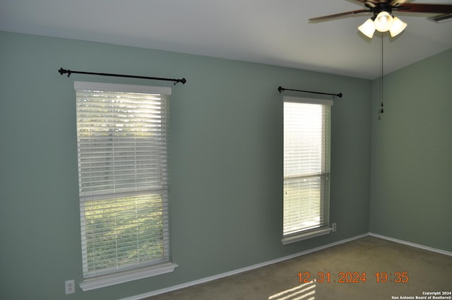 carpeted empty room featuring ceiling fan and a wealth of natural light